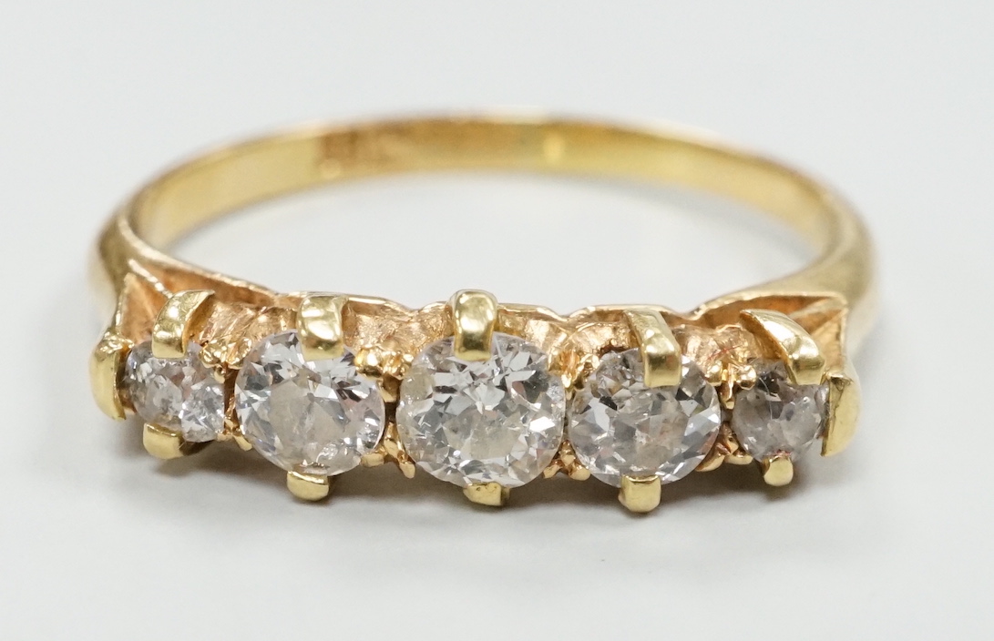 A gold and graduated five stone diamond set half hoop ring, size O/P, gross weight 2.8 grams.